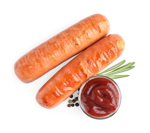 Photo of Delicious grilled sausages and sauce on white background, top view. Barbecue food