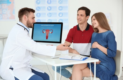 Photo of Gynecology consultation. Future parents with doctor in hospital