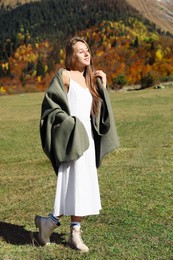 Young woman walking in beautiful mountains on sunny day