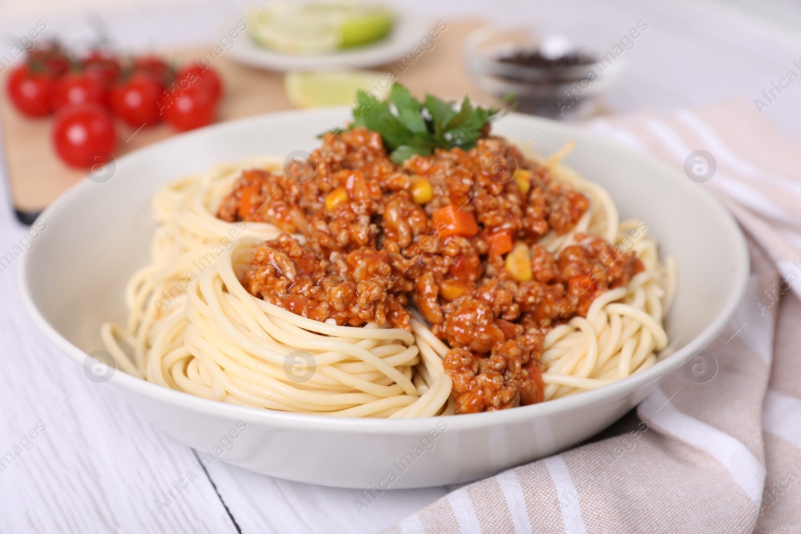 Photo of Tasty dish with fried minced meat, spaghetti, carrot and corn on white wooden table, closeup