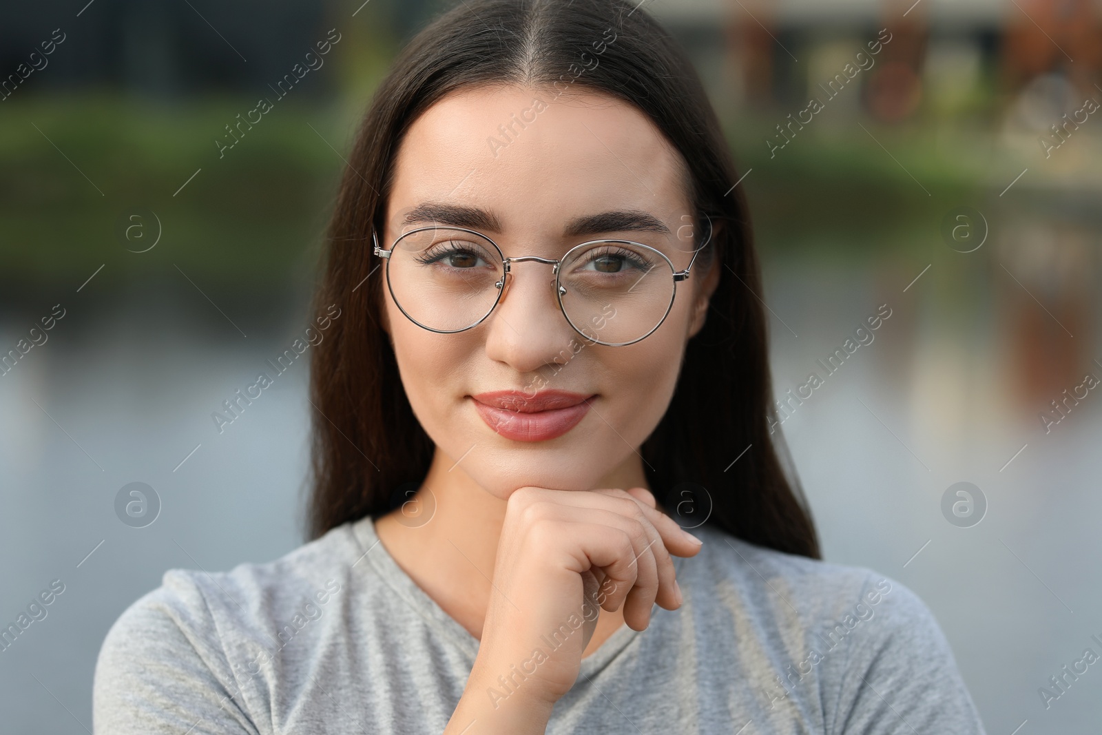 Photo of Portrait of beautiful woman in glasses on blurred background. Attractive lady looking into camera