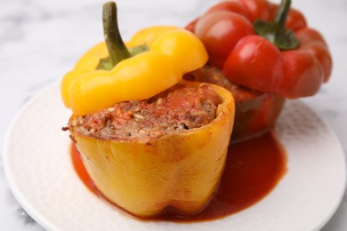 Photo of Delicious stuffed bell peppers served on white marble table, closeup