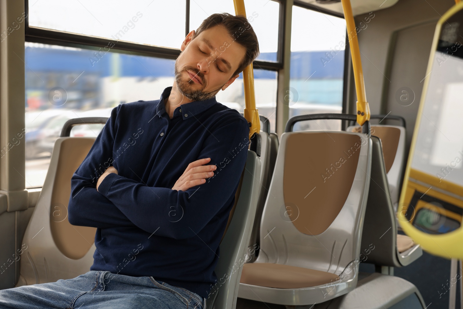 Photo of Tired man sleeping while sitting in public transport