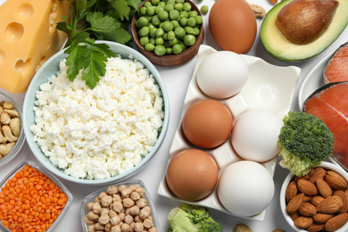 Photo of Different products rich in protein on white background, flat lay