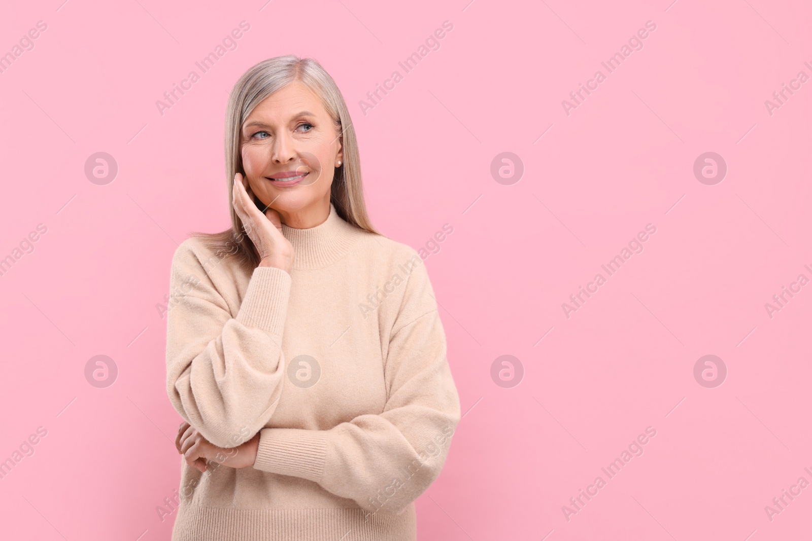 Photo of Portrait of beautiful middle aged woman on pink background, space for text