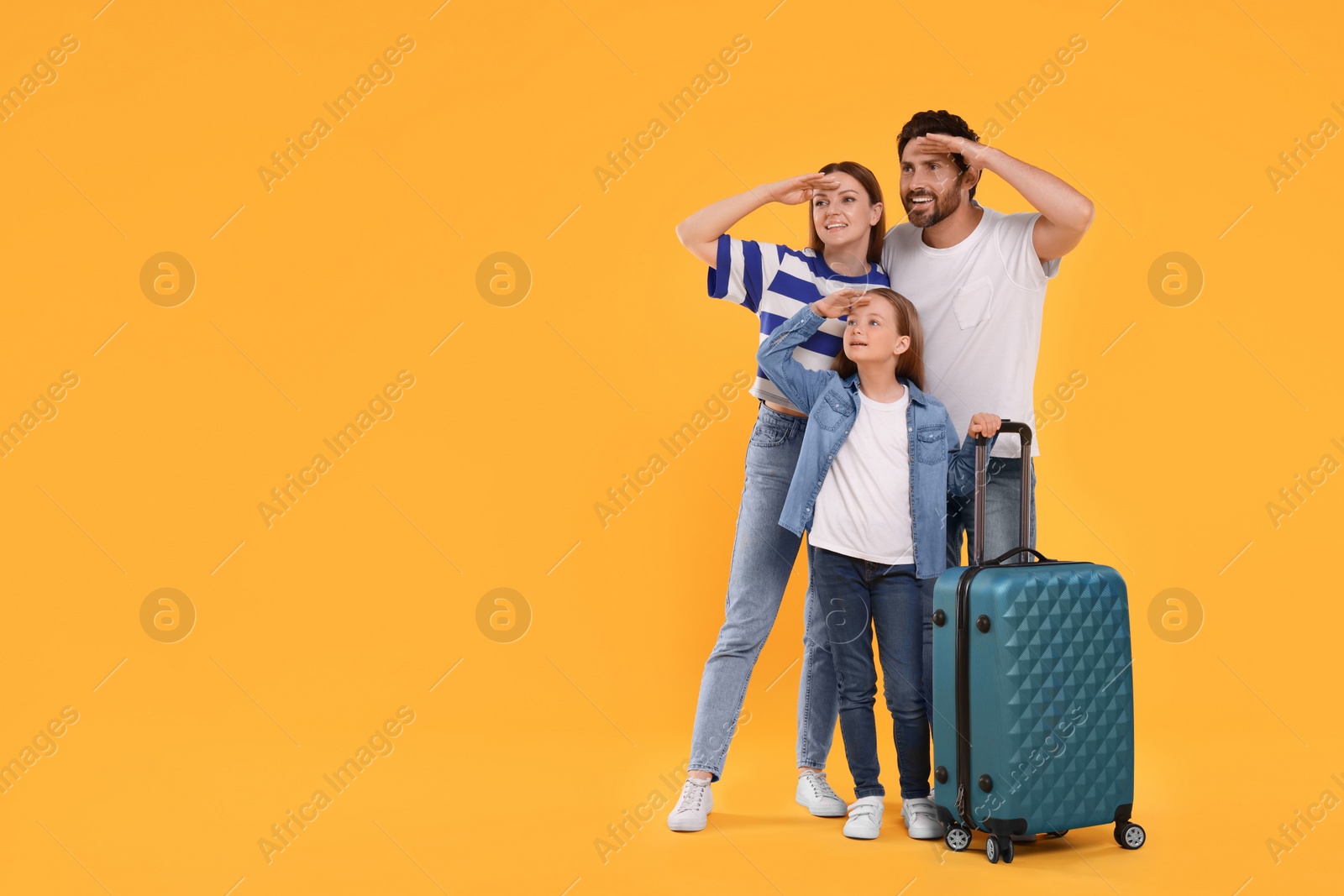 Photo of Happy family with green suitcase on orange background, space for text