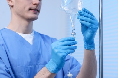 Photo of Nurse setting up IV drip in hospital, closeup