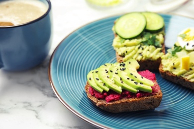 Crisp rye toasts with avocado on plate, closeup