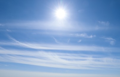 Photo of Bright sun and fluffy white clouds in blue sky