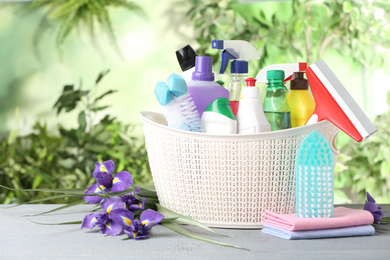 Photo of Spring flowers and cleaning supplies on light wooden table