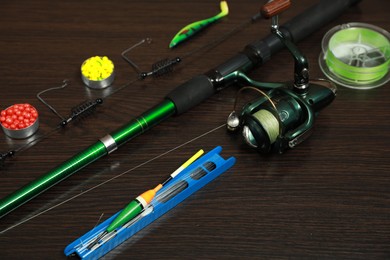 Photo of Modern fishing tackle on dark wooden background