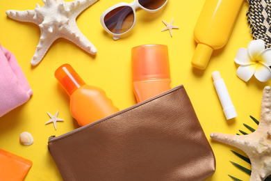 Photo of Flat lay composition with sun protection products on yellow background