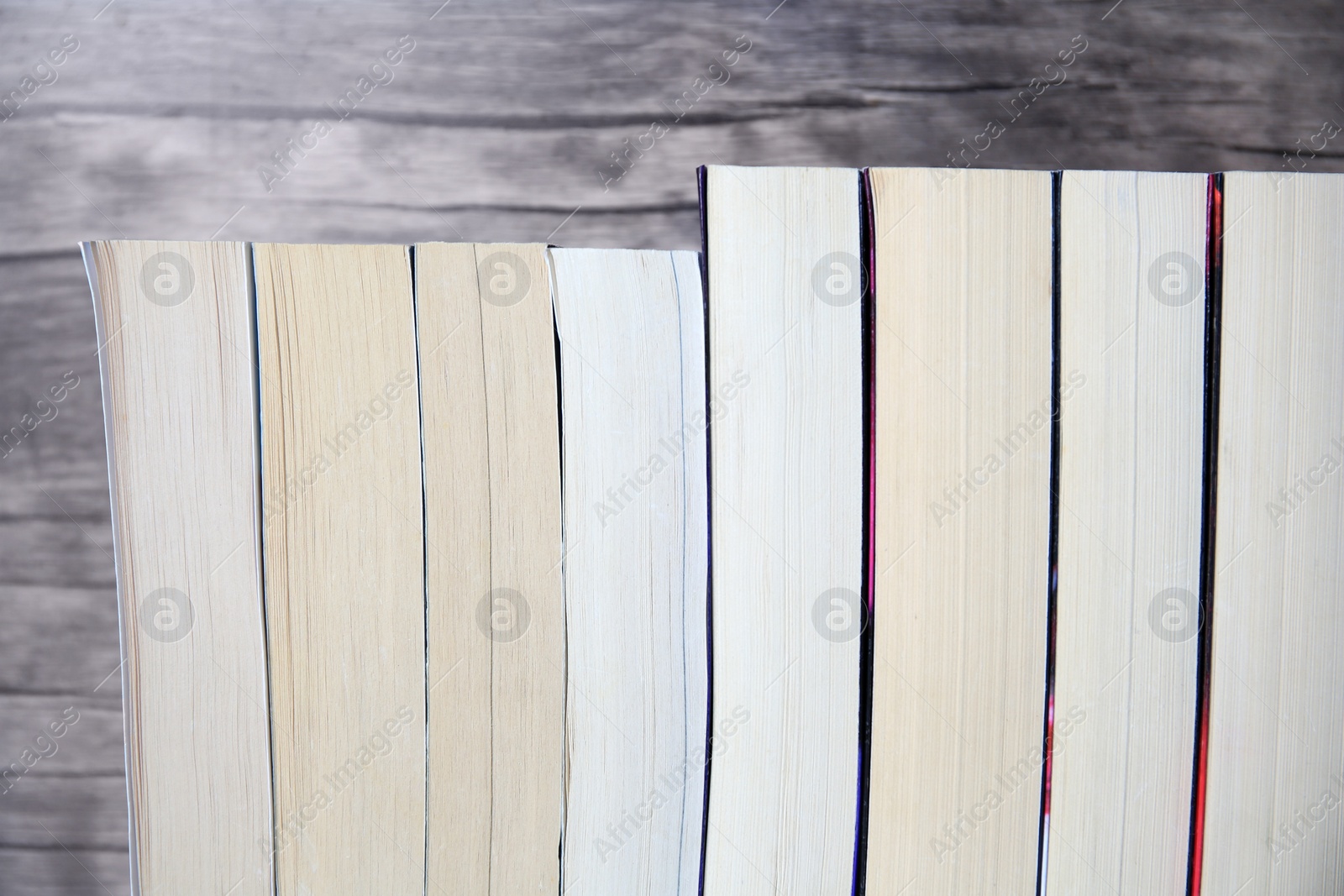 Photo of Collection of different books against wooden background, closeup