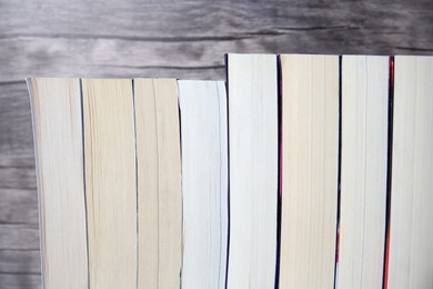 Collection of different books against wooden background, closeup