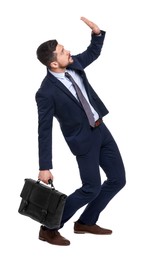 Handsome bearded businessman in suit with briefcase avoiding something on white background