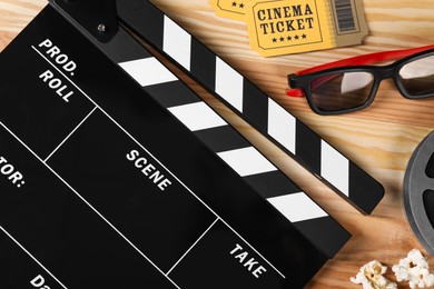 Flat lay composition with clapperboard and 3D glasses on wooden table