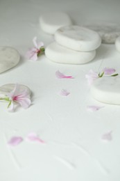 Photo of Spa stones and fresia flower on white table