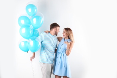 Young couple with air balloons on white background