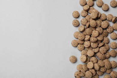 Photo of Vitamin pills on light grey background, top view. Space for text