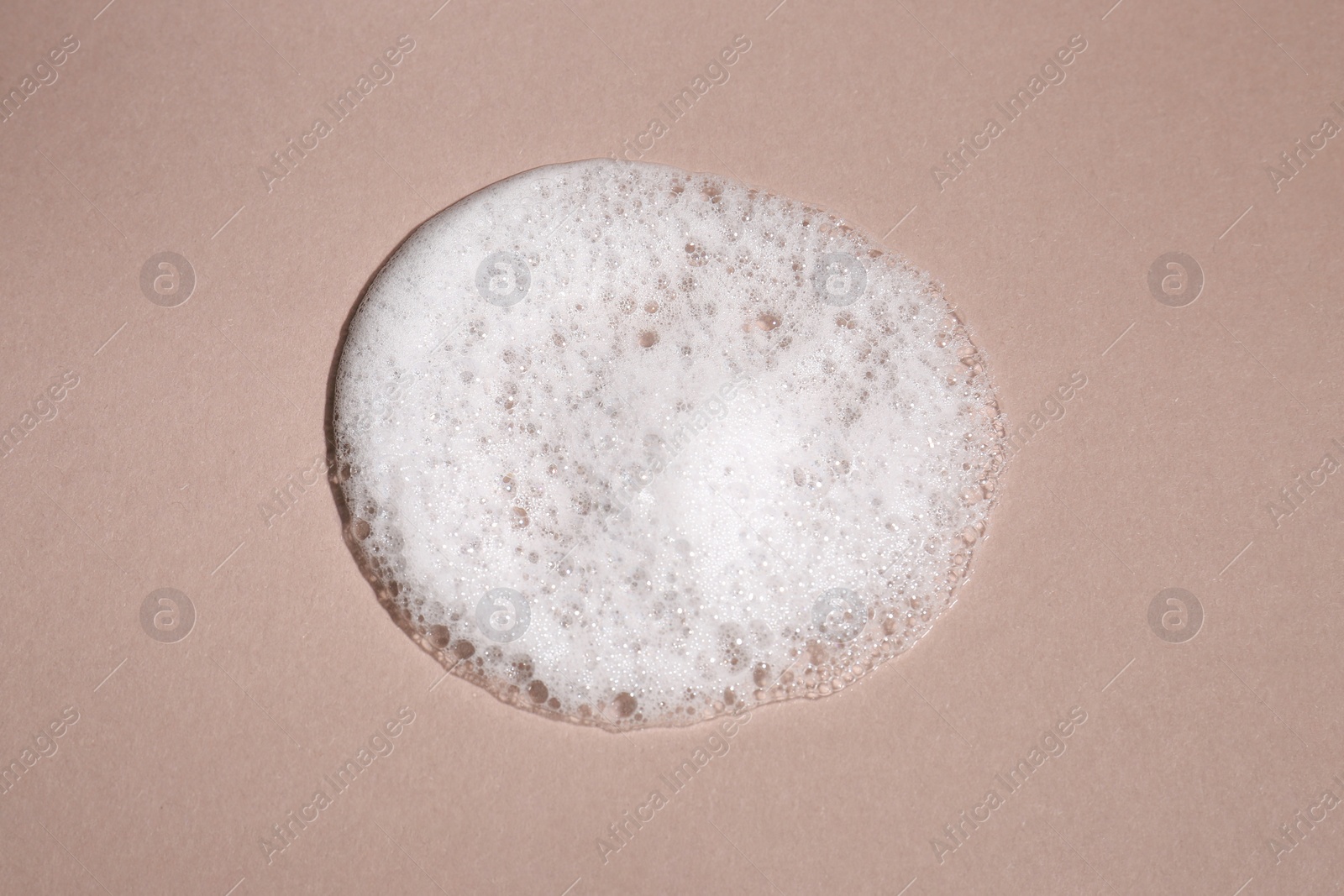 Photo of Foaming cleanser on brown background, above view. Skin care cosmetic