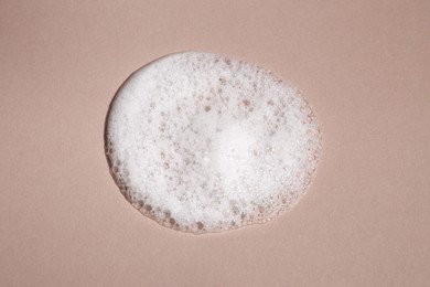 Photo of Foaming cleanser on brown background, above view. Skin care cosmetic