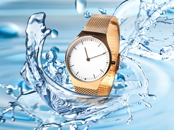 Luxury women's watch in water splashes demonstrating its waterproof