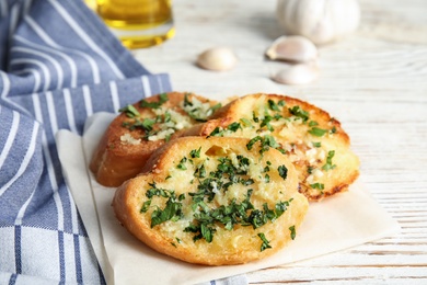 Photo of Slices of tasty garlic bread with herbs on table