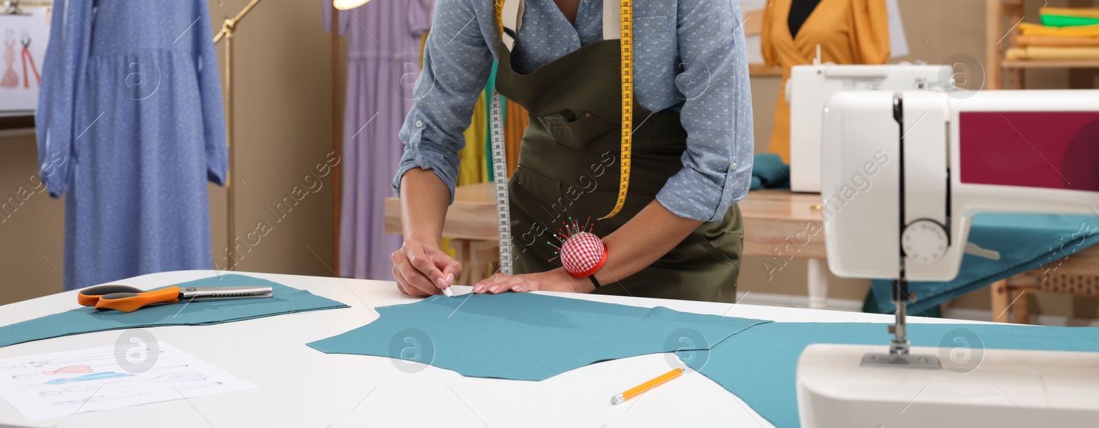 Image of Dressmaker marking fabric with chalk in workshop, closeup. Banner design