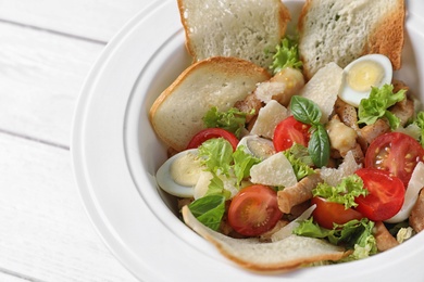 Photo of Plate with delicious fresh salad on table, closeup