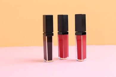 Photo of Many different lip glosses on color background