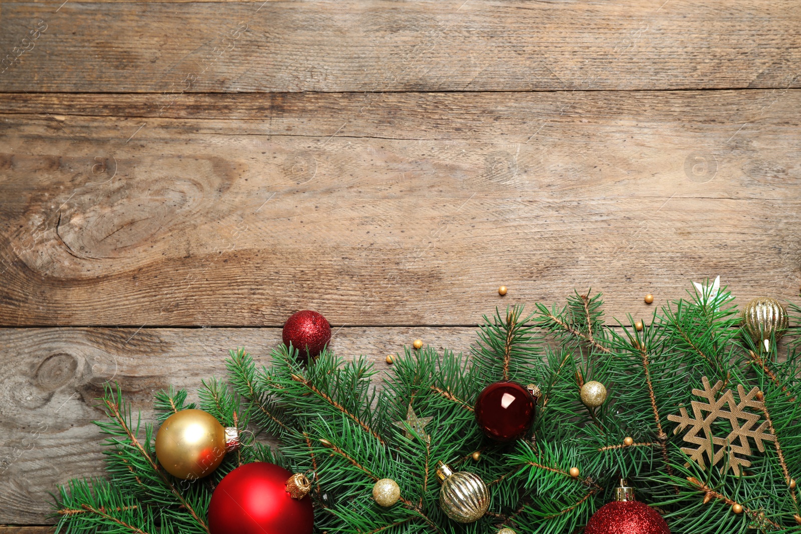 Photo of Fir tree branches with Christmas decoration on wooden background, flat lay. Space for text