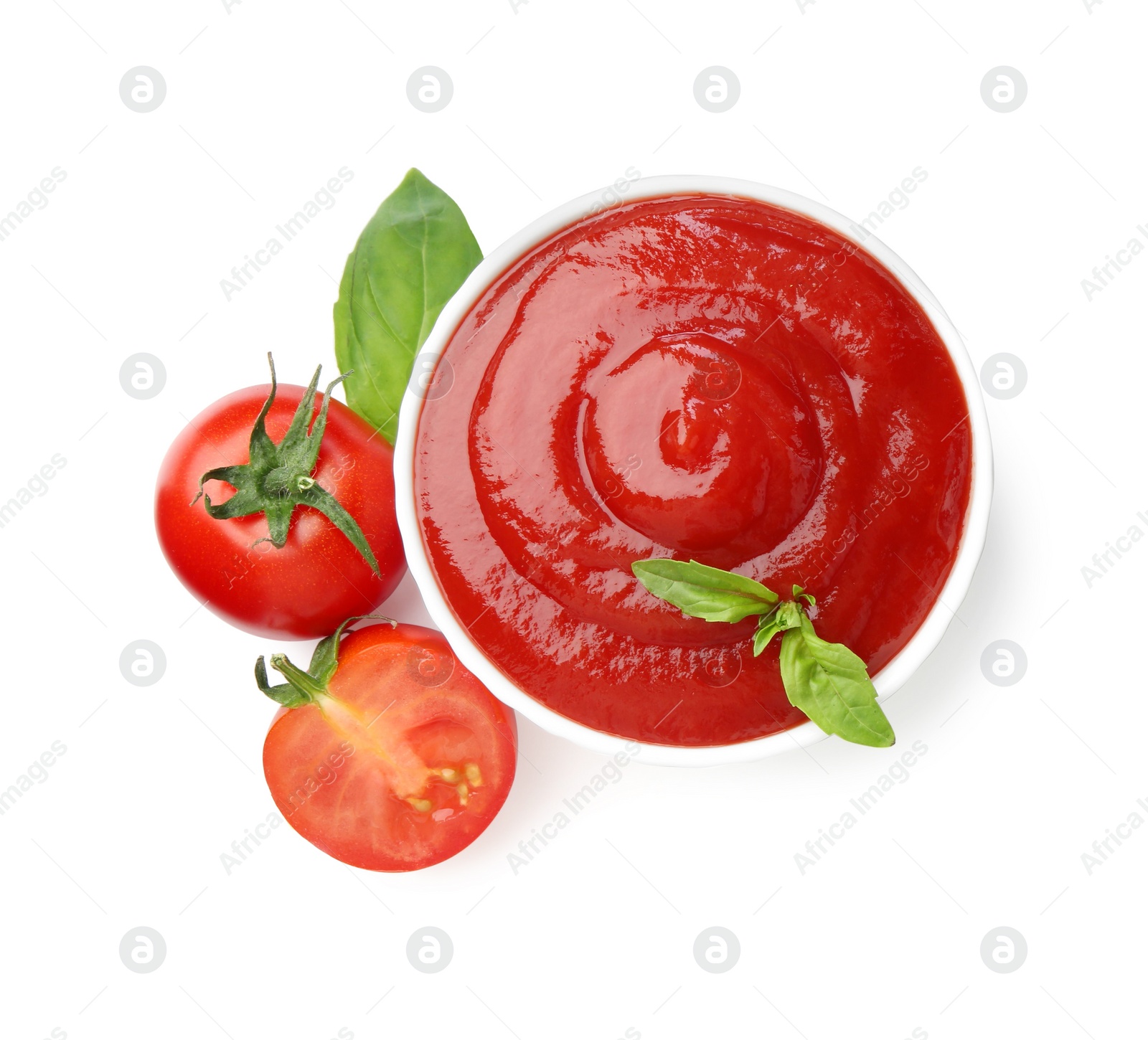 Photo of Tasty ketchup in bowl, basil and fresh tomatoes isolated on white, top view