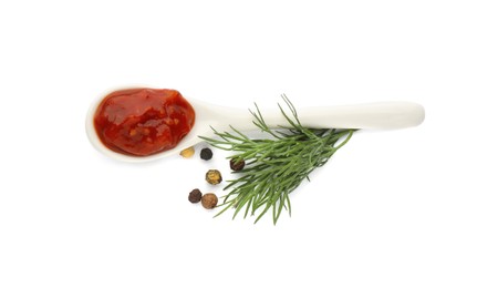 Photo of Delicious adjika sauce in spoon with dill and peppercorns on white background, top view