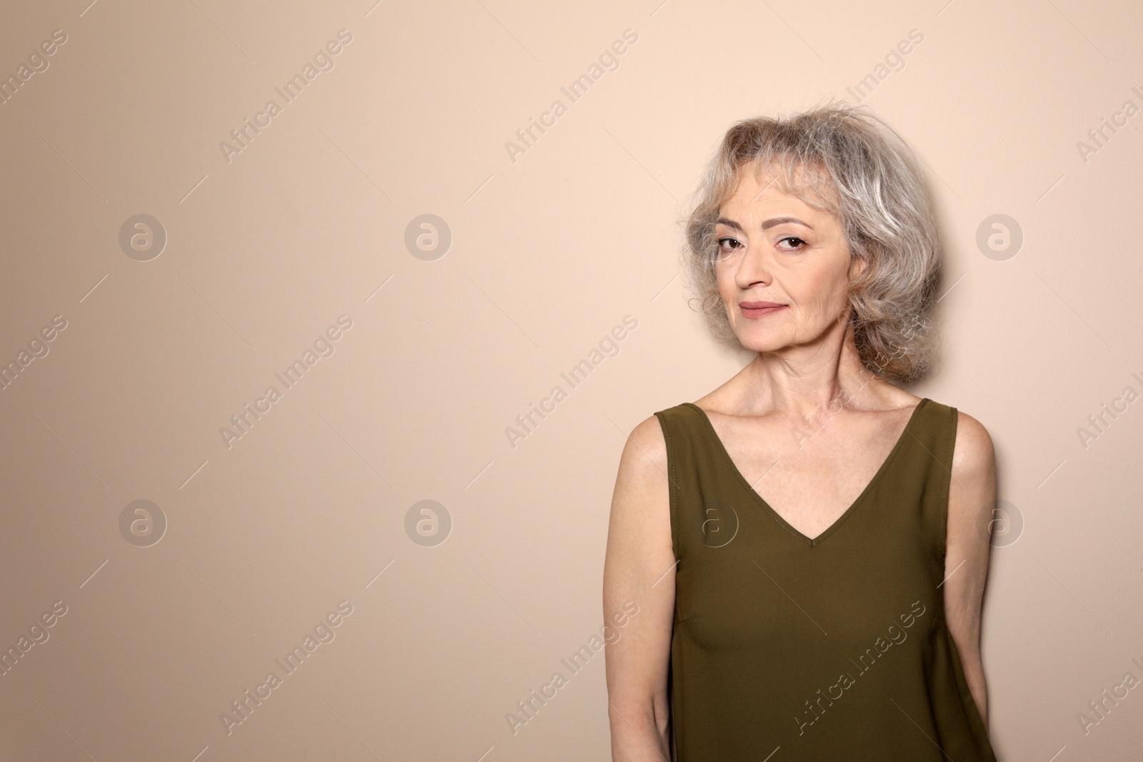 Photo of Portrait of mature woman on color background. Space for text