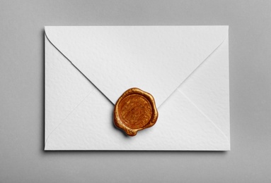 Photo of White envelope with wax seal on grey background, top view