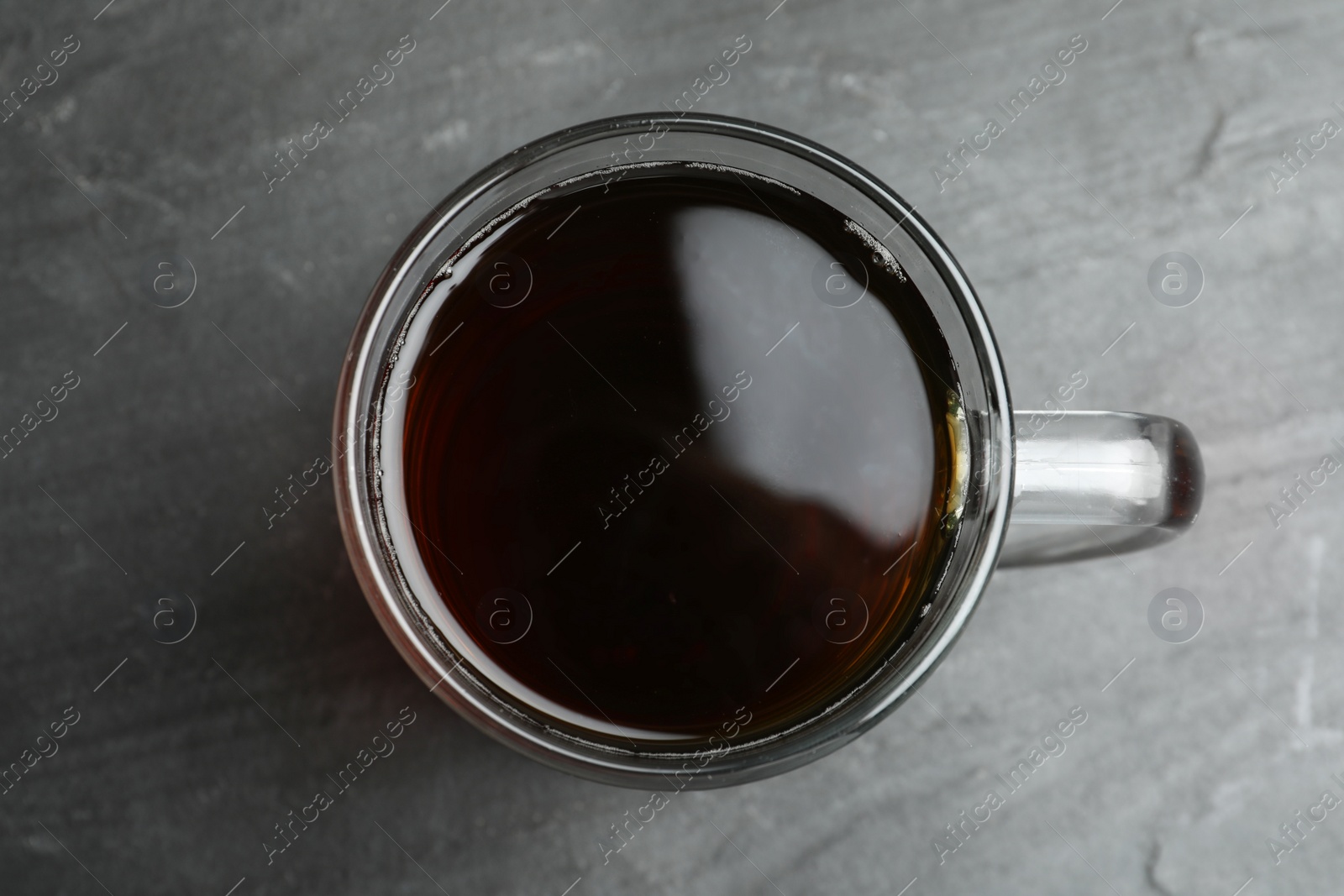 Photo of Mug of delicious kvass in mug on black table, top view