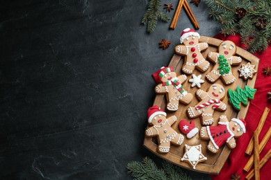 Flat lay composition with delicious Christmas cookies on black table, space for text