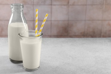 Photo of Glassware with tasty milk on light gray table, space for text