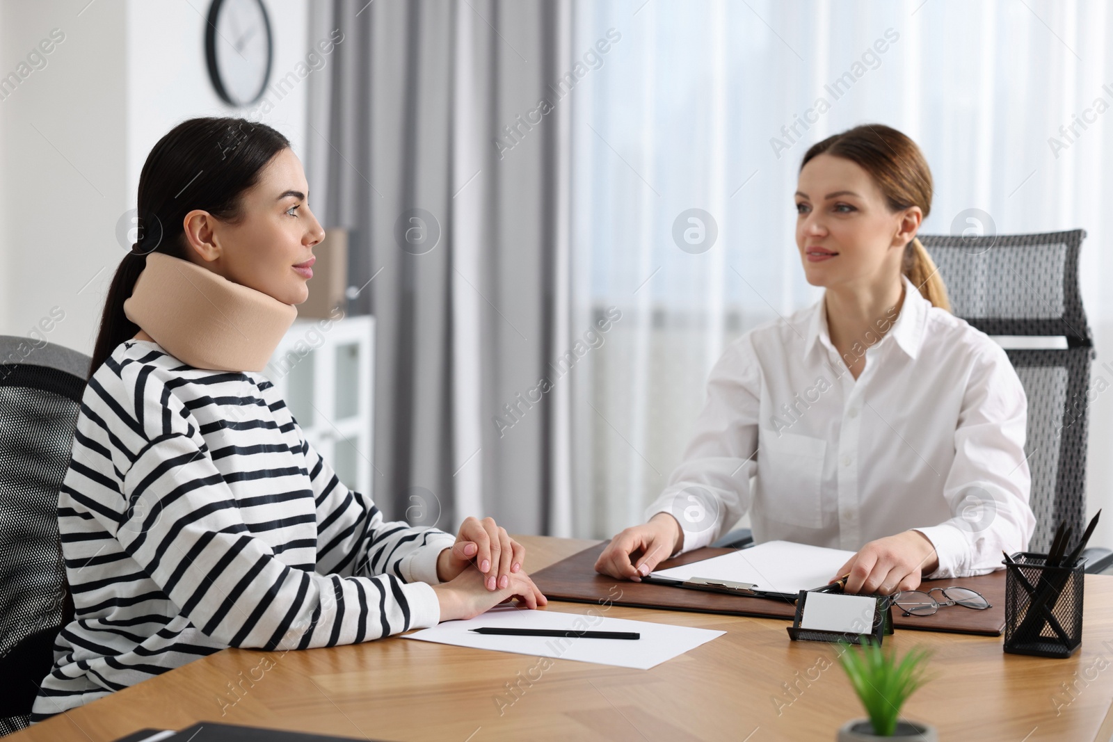 Photo of Injured woman having meeting with lawyer in office