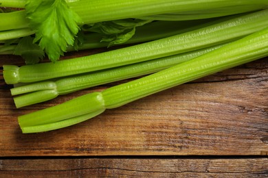 Fresh green celery bunches on wooden table, top view. Space for text