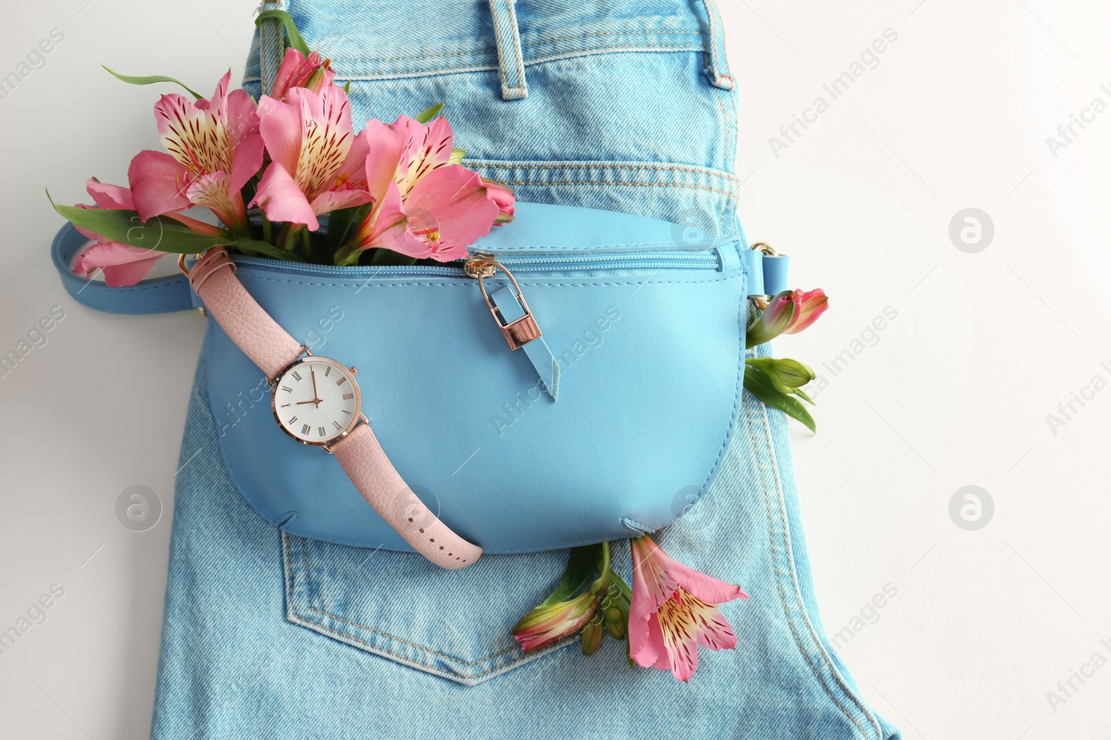 Photo of Flat lay composition with stylish bump bag and spring flowers on light background