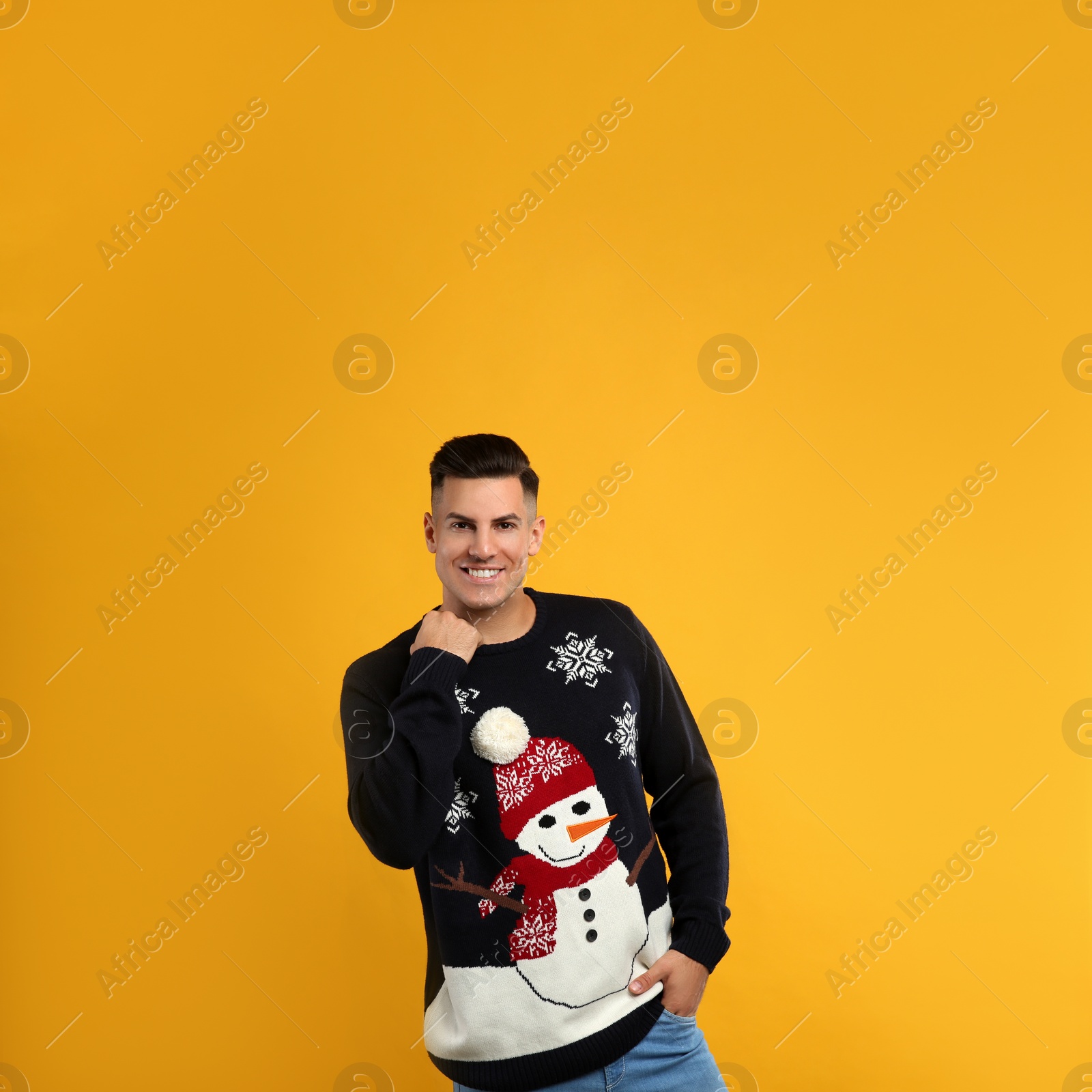 Photo of Handsome man in Christmas sweater on yellow background