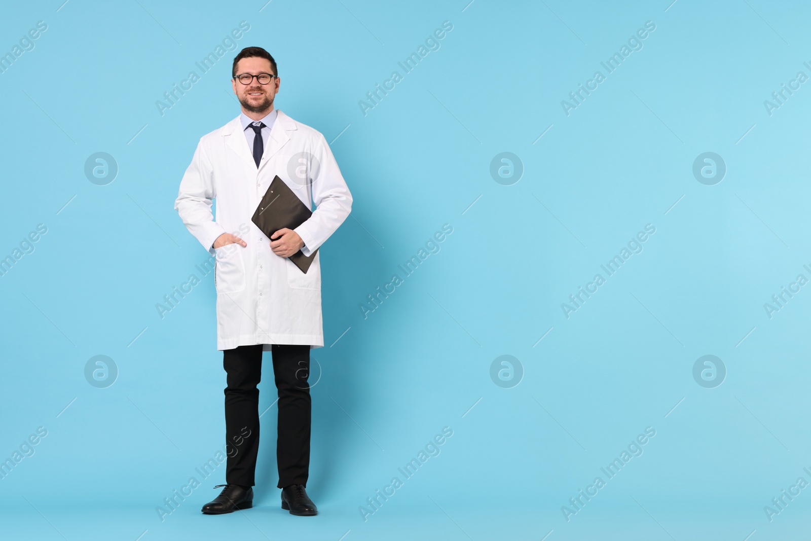 Photo of Doctor with clipboard on light blue background, space for text