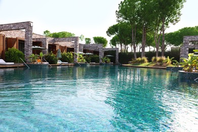 Swimming pool, exotic plants and sunbeds at luxury resort