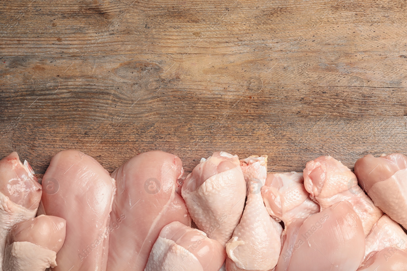 Photo of Fresh chicken meat on wooden table, flat lay. Space for text