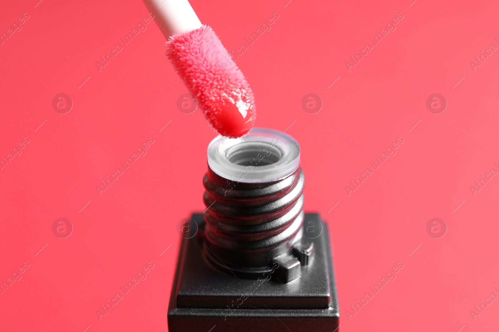 Photo of Applicator above liquid lipstick tube on color background