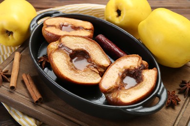 Photo of Tasty baked quinces with spices and honey in dish on table