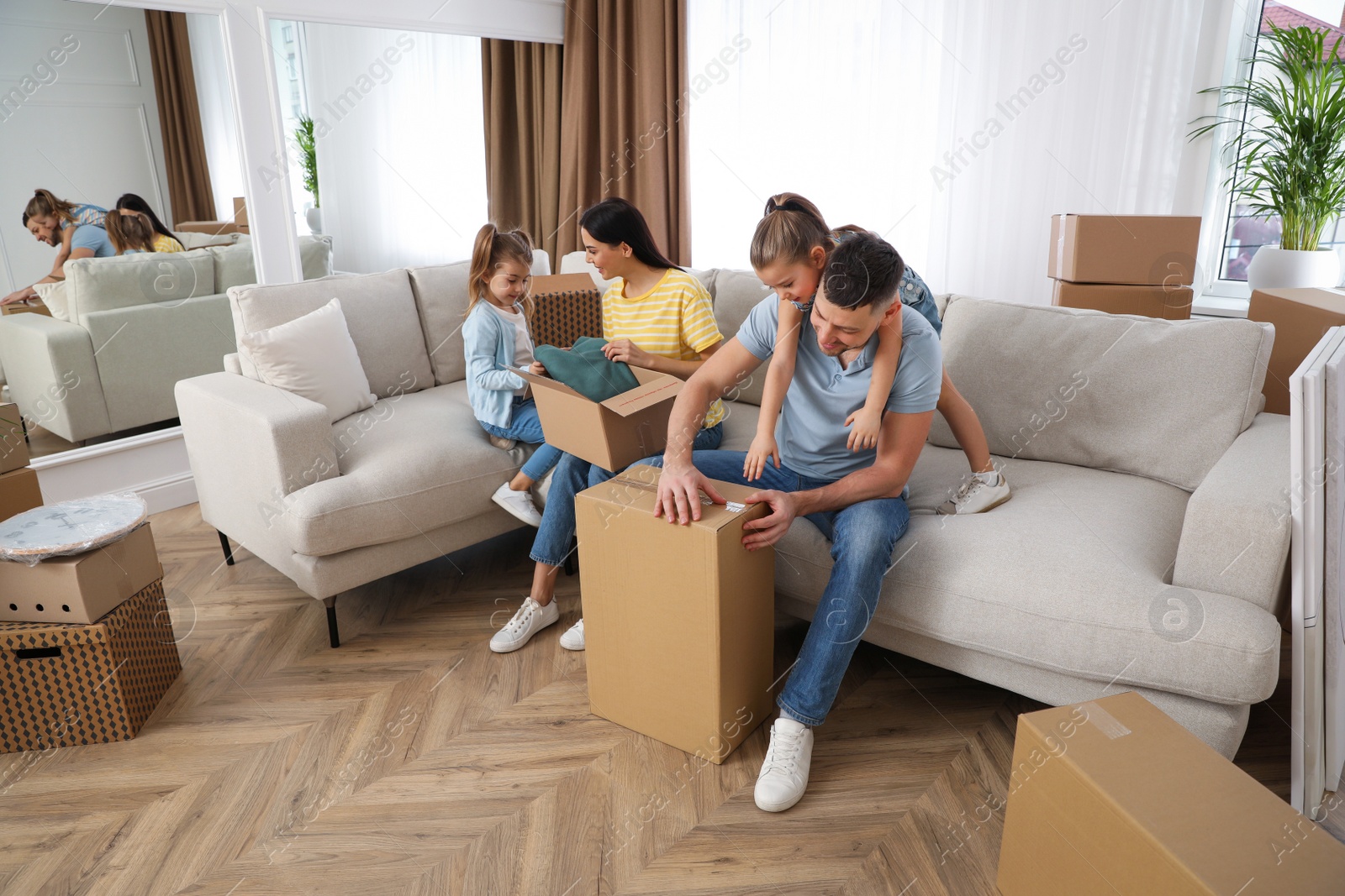 Photo of Happy family unpacking moving boxes at their new house