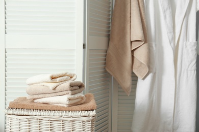 Stack of clean towels on laundry basket in bathroom