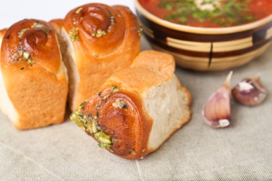 Photo of Delicious pampushky (buns with garlic) served for borsch on table, closeup. Traditional Ukrainian cuisine